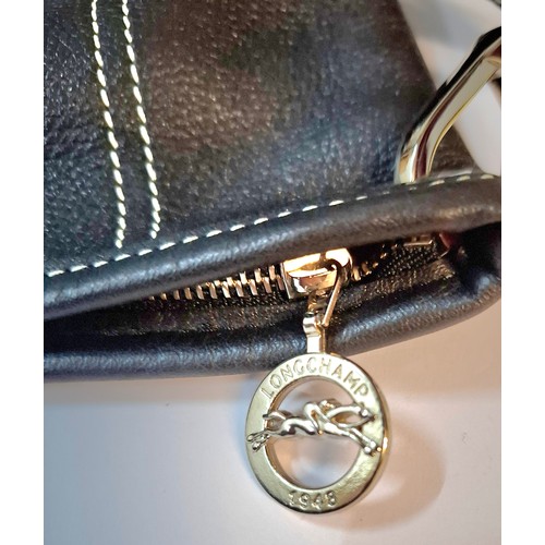 11 - Longchamp- A black leather crossbody bag, 26cm wide x 26cm high, having silver tone hardware, red br... 