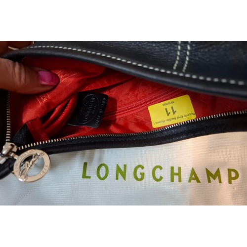 11 - Longchamp- A black leather crossbody bag, 26cm wide x 26cm high, having silver tone hardware, red br... 