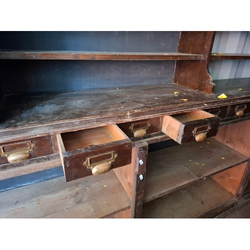 13 - An early 20th Century very large mahogany stained oak shop display cabinet on a plinth base having 1... 