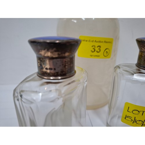 33 - A pair of French glass scent bottles having silver and blue enamelled lids together with a larger et... 