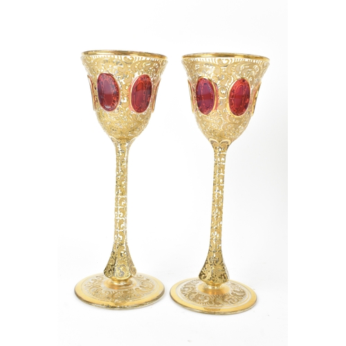33 - A set of six Bohemian gilt and enamelled wine glasses, possibly by Moser, each with tall slender ste... 