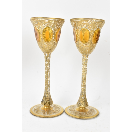 33 - A set of six Bohemian gilt and enamelled wine glasses, possibly by Moser, each with tall slender ste... 