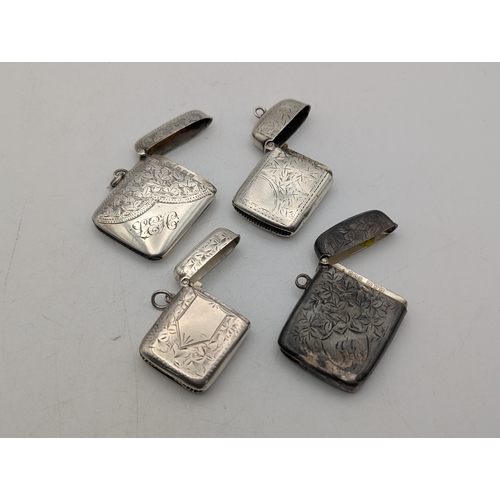 109 - Four silver vesta cases, all having floral engraved decoration, three with hinged lids and suspensio... 