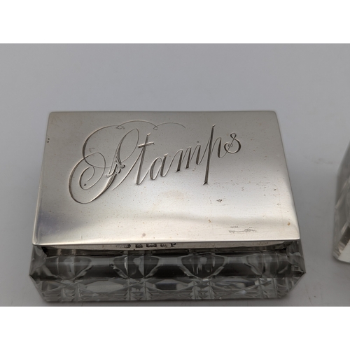 114 - A group of silver topped and silver handled desk top items to include a stamp pot, two ink pots, a l... 