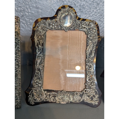 118 - Three silver fronted photo frames to include a floral embossed tortoiseshell example, together with ... 