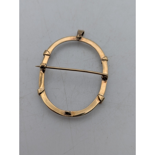 73 - A yellow metal brooch/pendant, framed tested as 9ct gold having four prongs and suspension loop in o... 