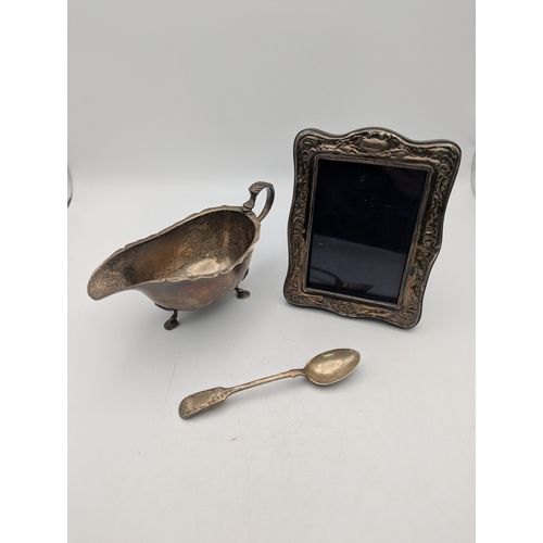 74 - Silver to include a sauce boat hallmarked Birmingham 1962, 71g, a silver fronted photo frame and a t... 
