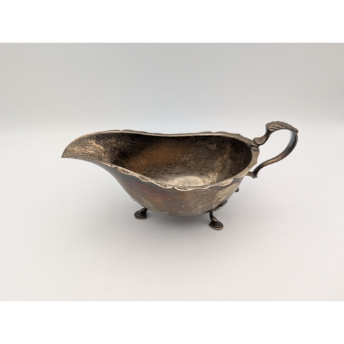 74 - Silver to include a sauce boat hallmarked Birmingham 1962, 71g, a silver fronted photo frame and a t... 