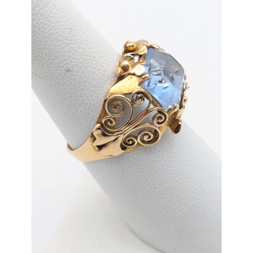 78 - An aquamarine and 18ct yellow gold ring having a floral pierced design and scroll pierced shoulders ... 