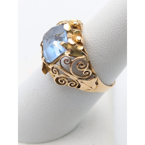 78 - An aquamarine and 18ct yellow gold ring having a floral pierced design and scroll pierced shoulders ... 