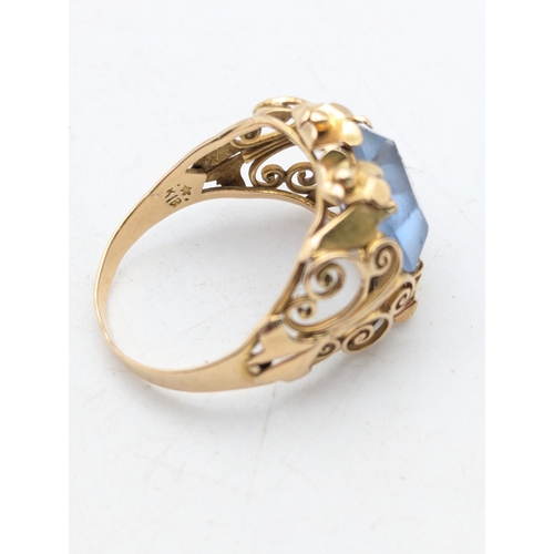 78 - An aquamarine and 18ct yellow gold ring having a floral pierced design and scroll pierced shoulders ... 