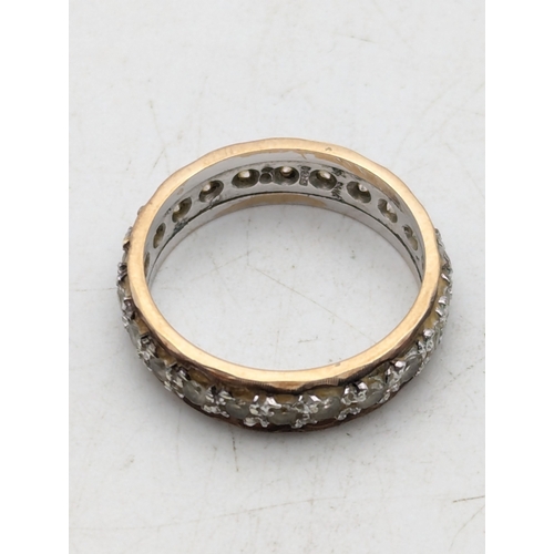83 - A two-tone 9ct gold eternity ring set with three white stones possibly sapphires, size N 1/2, 3.9g
L... 