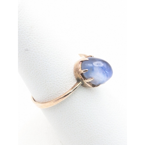 93 - A blue sapphire cabochon claw set on a yellow metal shank, tested as 9ct gold size Q 1/2, 2.4g and a... 