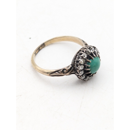 94 - A diamond and turquoise halo ring with a central turquoise in a white metal claw setting, on a yello... 