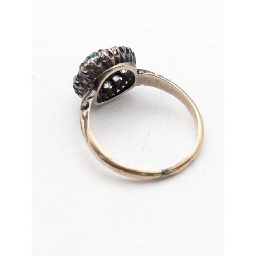 94 - A diamond and turquoise halo ring with a central turquoise in a white metal claw setting, on a yello... 