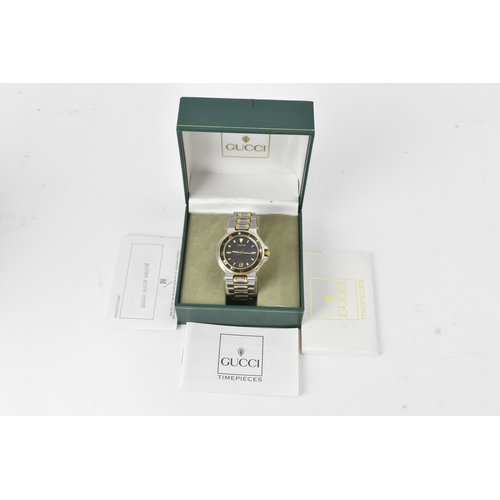 8 - A Gucci 9700M, quartz, gents, stainless steel and gold-plated wristwatch, circa 1995, the textured b... 
