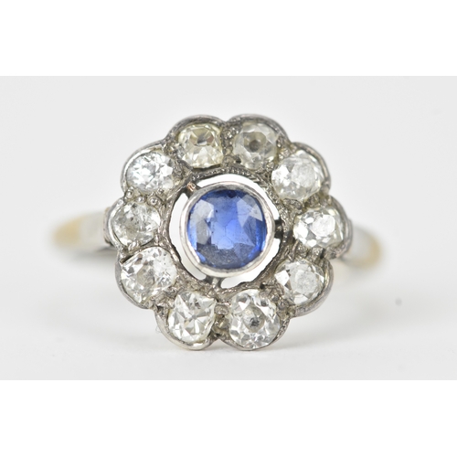 18 - A sapphire and diamond platinum cluster ring, the round-cut sapphire measuring approximately 4.3mm d... 