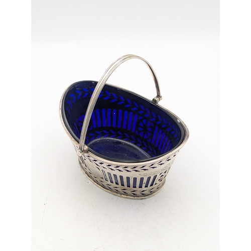 11 - A Victorian silver sugar basket having pierced decoration and blue glass liner by Henry Wilkinson an... 