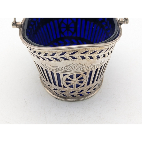 11 - A Victorian silver sugar basket having pierced decoration and blue glass liner by Henry Wilkinson an... 