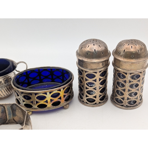 17 - Silver condiment pots and one napkin ring to include a pair of pepper pots with pierced decoration a... 