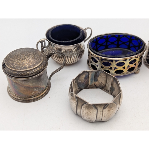 17 - Silver condiment pots and one napkin ring to include a pair of pepper pots with pierced decoration a... 