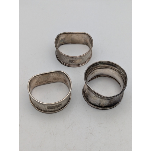 20 - Three silver napkin rings two Broadway and Co Elizabeth II napkin rings with machine turned decorati... 