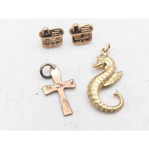 25 - A 9ct yellow gold seahorse pendant together with a yellow metal cross pendant and a pair of yellow m... 
