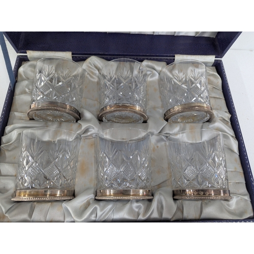 29 - A set of six crystal cut glass tumblers with silver rims hallmarked Birmingham 1980 housed in a fitt... 