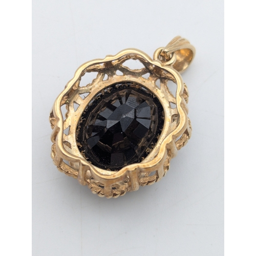 48 - A 9ct yellow gold and smokey quartz pendant comprising of an oval cut claw set quartz stone mounted ... 