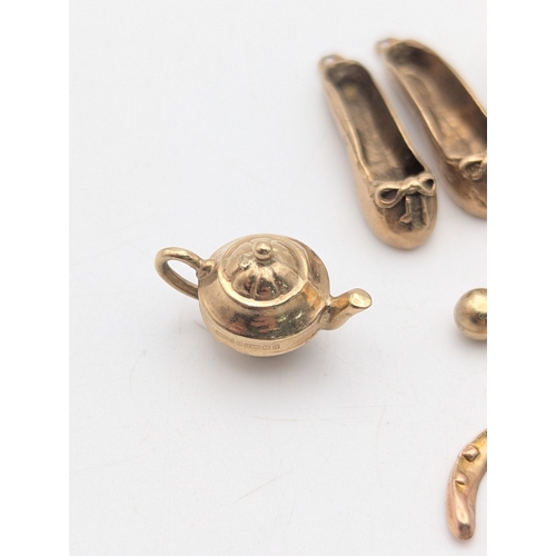 50 - Seven 9ct yellow gold charms comprising of three rings, two ballet shoes, a high heel, teapot and mu... 