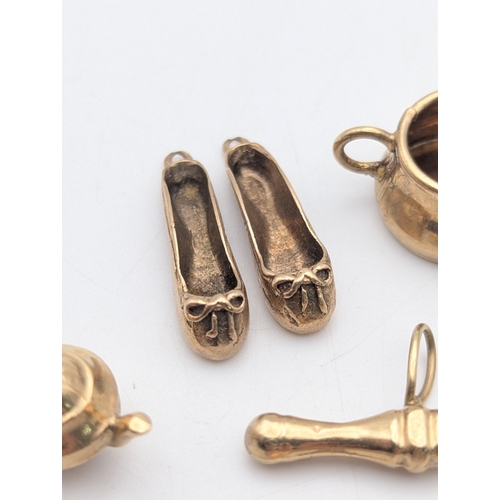 50 - Seven 9ct yellow gold charms comprising of three rings, two ballet shoes, a high heel, teapot and mu... 