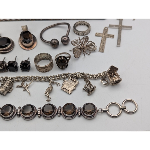 59 - Silver and white metal jewellery to include a sterling silver charm bracelet with an assortment of c... 