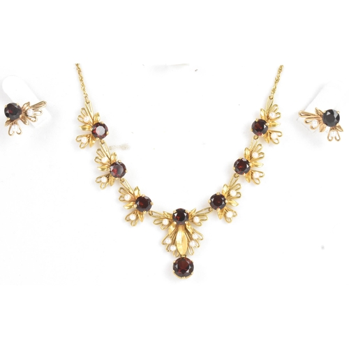 60A - A 9ct gold garnet and seed pearl necklace and earrings suite, the necklace of foliate design with ro... 