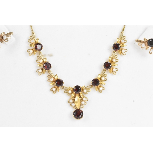 60A - A 9ct gold garnet and seed pearl necklace and earrings suite, the necklace of foliate design with ro... 