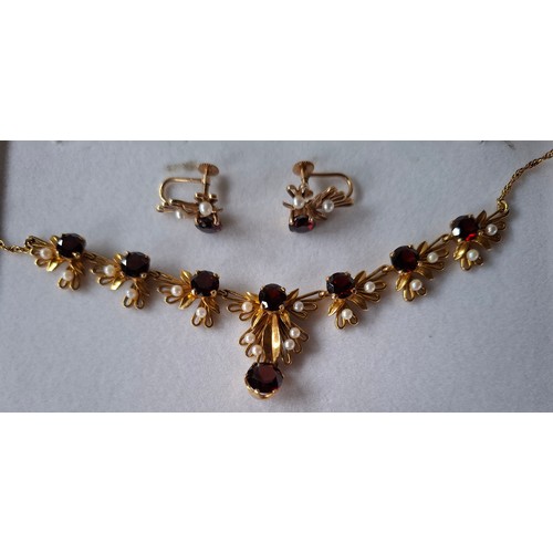 60A - A 9ct gold garnet and seed pearl necklace and earrings suite, the necklace of foliate design with ro... 