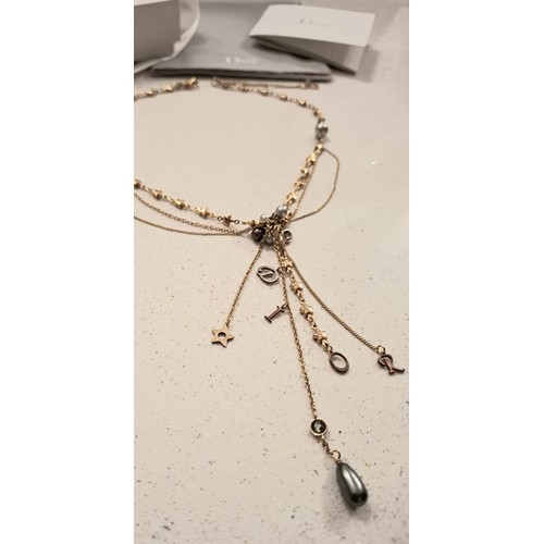 7 - Christian Dior- A gold tone multi chain necklace having star and faux pearl accents, the pendant let... 