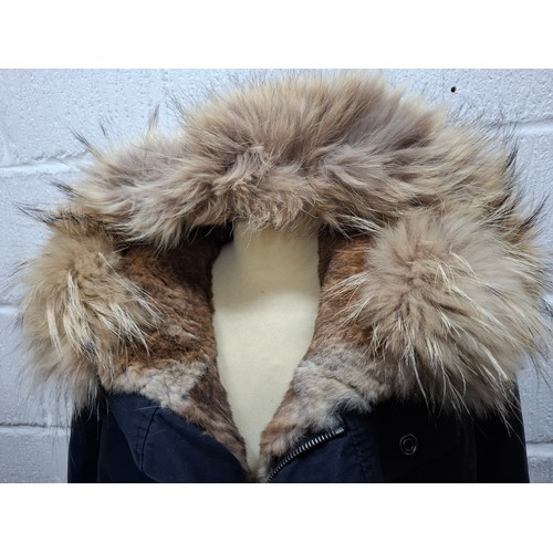 27 - Yves Salomon- A gents navy hooded parka coat having a detachable brown rabbit fur lining and coyote ... 