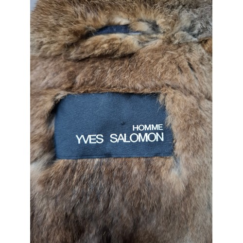 27 - Yves Salomon- A gents navy hooded parka coat having a detachable brown rabbit fur lining and coyote ... 