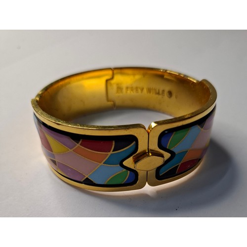 47 - Frey Wille- A gilt metal and enamel hinged bangle with harlequin design in various colours, to fit m... 