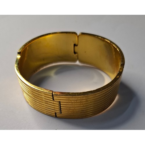 47 - Frey Wille- A gilt metal and enamel hinged bangle with harlequin design in various colours, to fit m... 