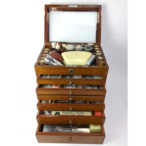 A 1940s dentists portable mahogany cabinet, with a hinged lid and chrome carrying handle, over six graduated drawers, the contents to include glass bottles, drill heads, toothpicks, scissors,  hand pieces, knives and other items 37 cm high 33 cm wide 23 cm deep
Location:
If there is no condition report shown, please request