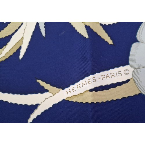15 - Hermes- A 1990's Tahiti by Cathy Latham silk scarf having a navy ground with gold, cream and grey fl... 