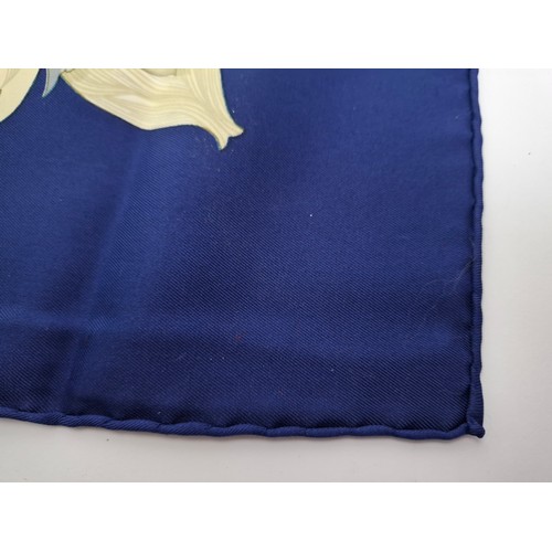 15 - Hermes- A 1990's Tahiti by Cathy Latham silk scarf having a navy ground with gold, cream and grey fl... 
