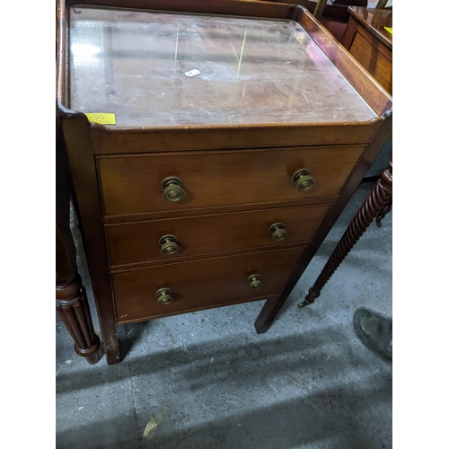 534 - A Victorian tray top style mahogany bedside chest of three drawers with brass handles, glass top, on... 