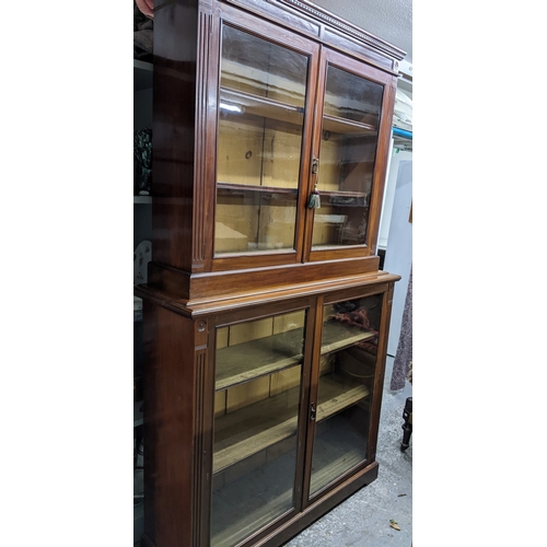535 - A Victorian mahogany bookcase, the top with dentil moulded cornice, and flower head ornamental twin ... 