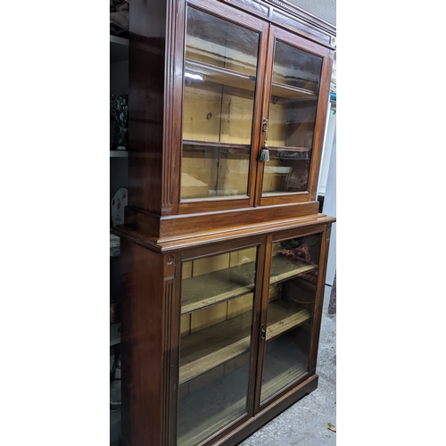 535 - A Victorian mahogany bookcase, the top with dentil moulded cornice, and flower head ornamental twin ... 