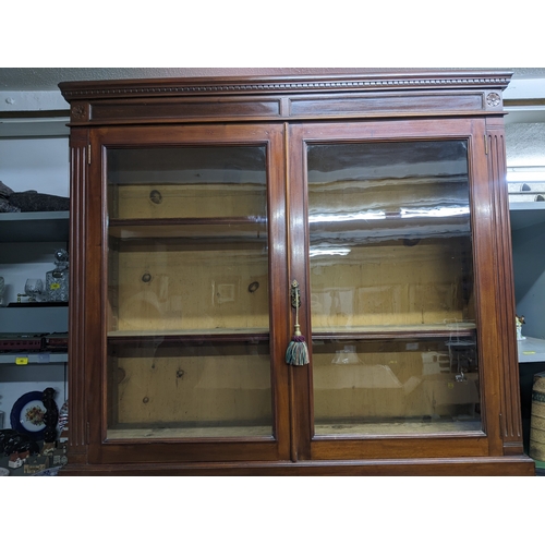 535 - A Victorian mahogany bookcase, the top with dentil moulded cornice, and flower head ornamental twin ... 