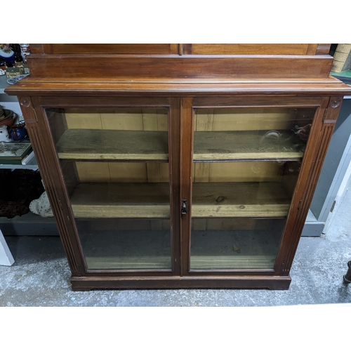 535 - A Victorian mahogany bookcase, the top with dentil moulded cornice, and flower head ornamental twin ... 
