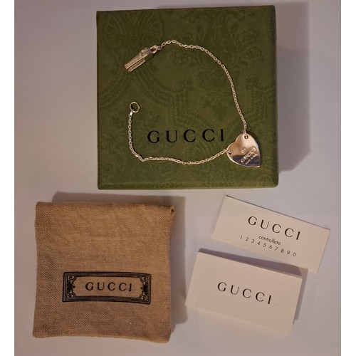 34 - Gucci- A fine Sterling silver chain bracelet with heart pendant, made in Italy having a branded dust... 