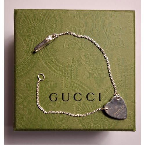 34 - Gucci- A fine Sterling silver chain bracelet with heart pendant, made in Italy having a branded dust... 